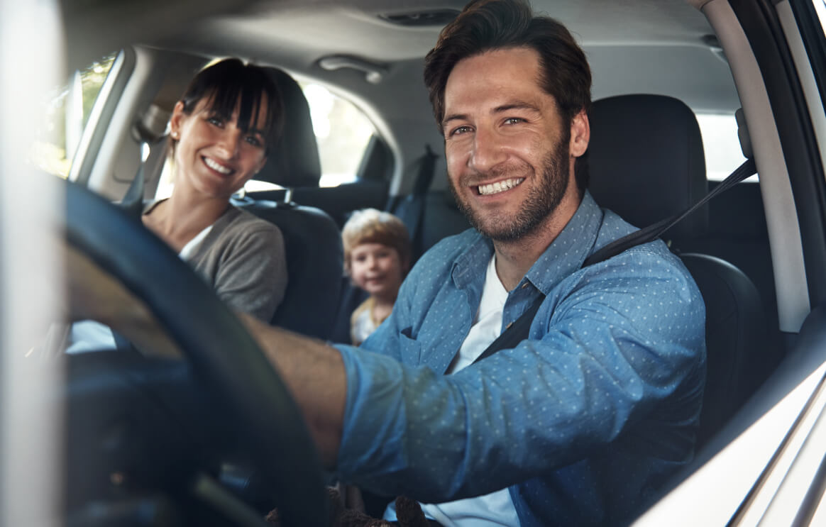 man driving family in car